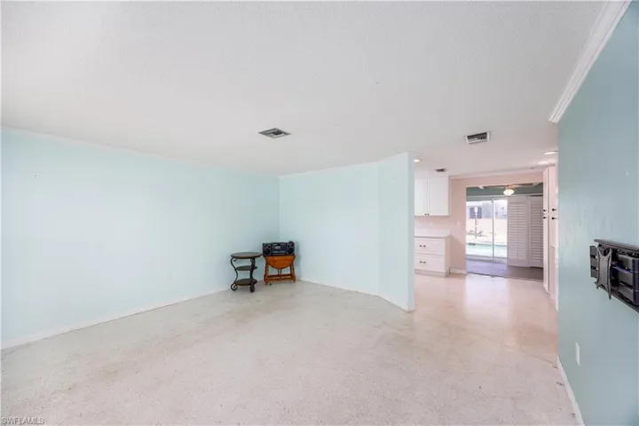 Unfurnished room with baseboards, ornamental molding, a textured ceiling, and visible vents