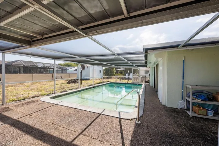 Pool with a patio, an outbuilding, a lanai, and a storage shed