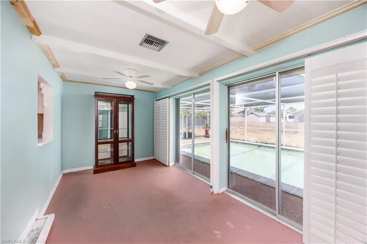 Unfurnished sunroom featuring visible vents, beam ceiling, and french doors