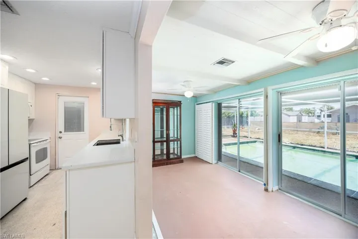 Kitchen featuring a ceiling fan, light countertops, white cabinets, recessed lighting, and white appliances