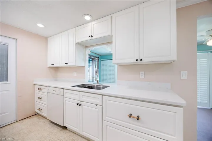 Kitchen featuring a ceiling fan, white dishwasher, recessed lighting, white cabinets, and a sink