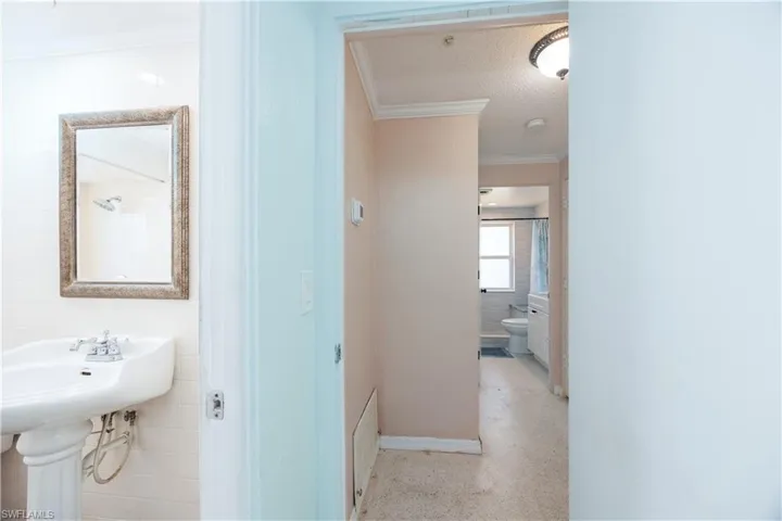 Bathroom featuring toilet, baseboards, and ornamental molding