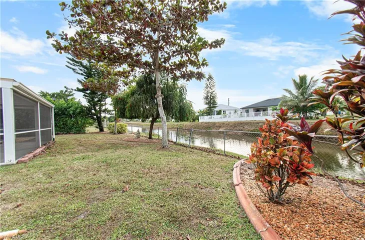 Fenced backyard featuring a water view and a sunroom