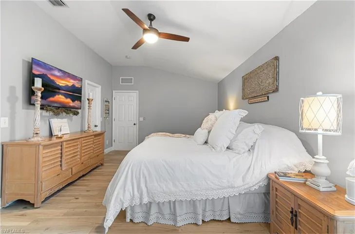 Bedroom featuring vaulted ceiling, light wood finished floors, and a ceiling fan