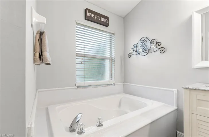 Full bathroom with a garden tub and vanity