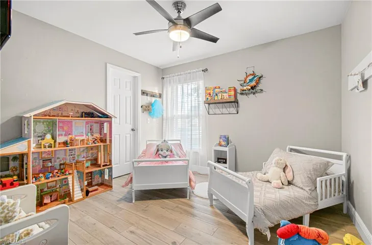 Bedroom with light wood finished floors and a ceiling fan