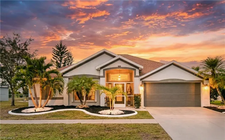 View of front of property featuring a front lawn, stucco siding, driveway, and a garage