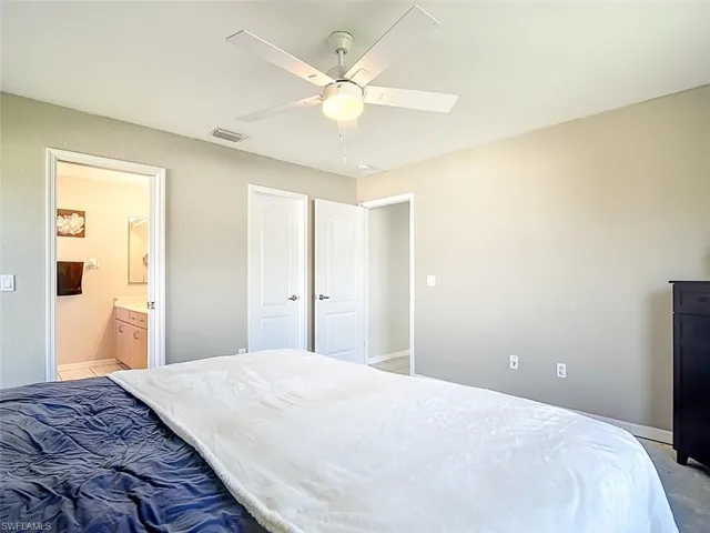 Bedroom featuring ensuite bathroom and a ceiling fan