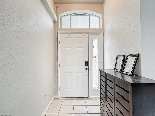 Foyer featuring a textured wall and light tile patterned flooring