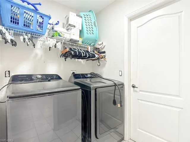Washroom featuring independent washer and dryer and tile patterned floors