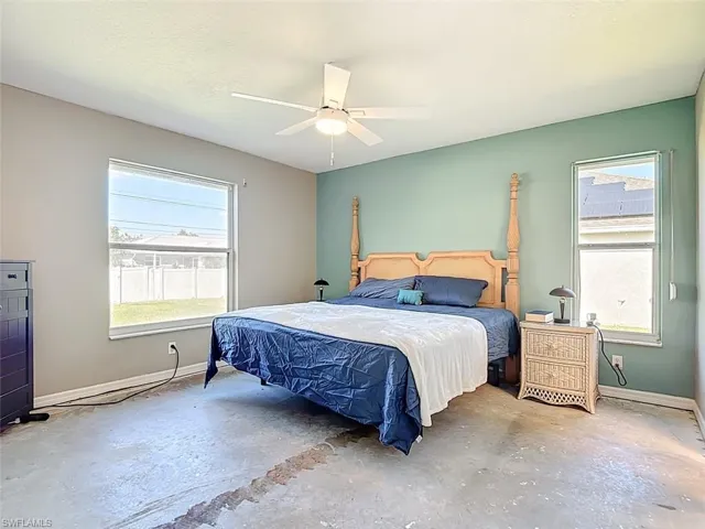 Bedroom with concrete flooring and a ceiling fan