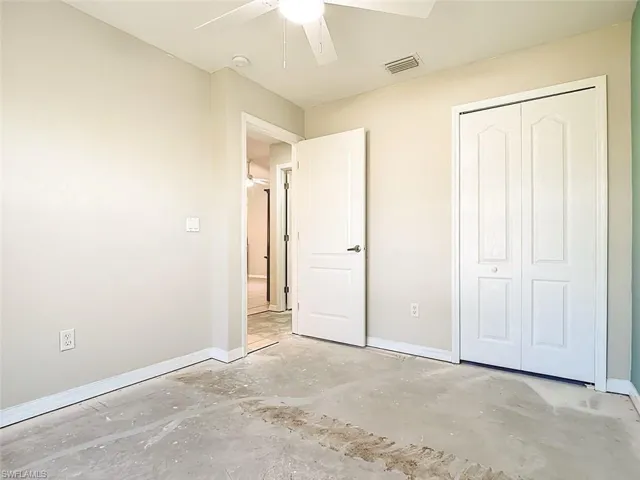 Unfurnished bedroom with ceiling fan and a closet