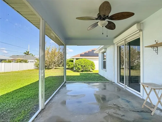 Unfurnished sunroom featuring ceiling fan and a patio