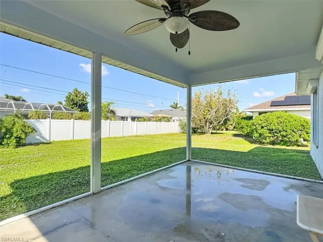 Unfurnished sunroom with a ceiling fan, a patio area, and plenty of natural light