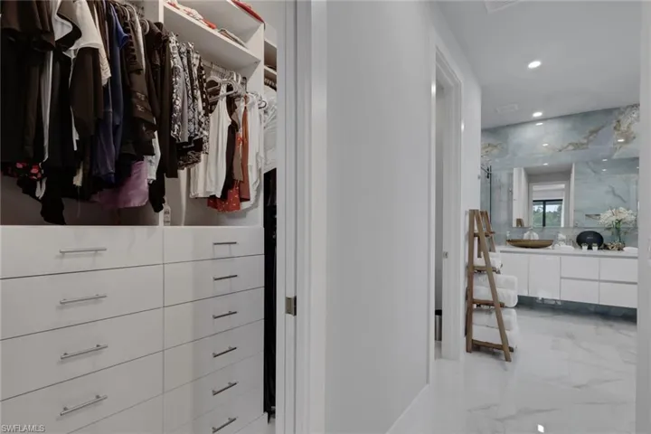 Primary suite walk in closet with custom storage