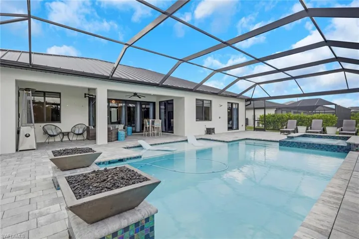 14' x 28' upgraded pool features a sun shelf with bubblers, an integrated spa/Jacuzzi, and dramatic fire bowls. The oversized paver pool deck and approximately 60' x 23' screened pool enclosure feature a picture-frame design that maximizes the relaxing waterfront views.