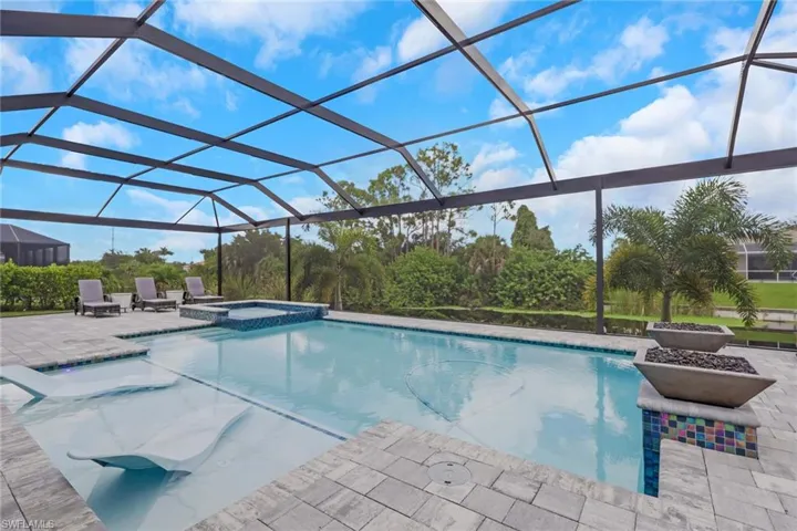 14' x 28' upgraded pool features a sun shelf with bubblers, an integrated spa/Jacuzzi, and dramatic fire bowls. The oversized paver pool deck and approximately 60' x 23' screened pool enclosure feature a picture-frame design that maximizes the relaxing waterfront views.