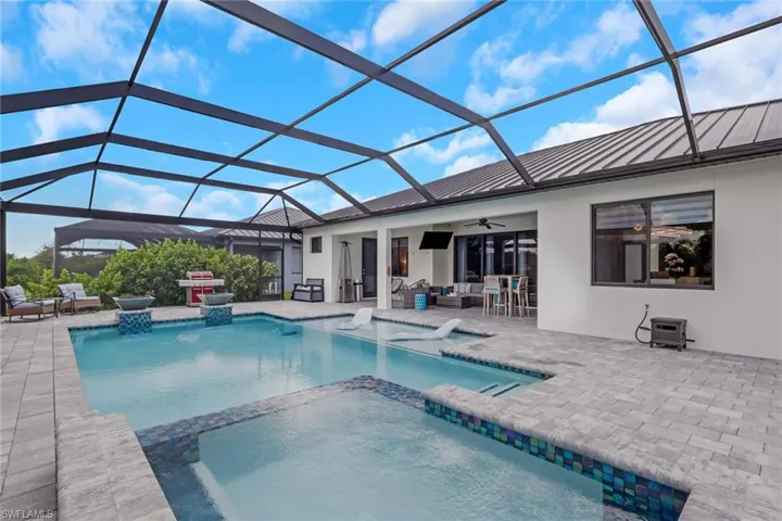 14' x 28' upgraded pool features a sun shelf with bubblers, an integrated spa/Jacuzzi, and dramatic fire bowls. The oversized paver pool deck and approximately 60' x 23' screened pool enclosure feature a picture-frame design that maximizes the relaxing waterfront views.