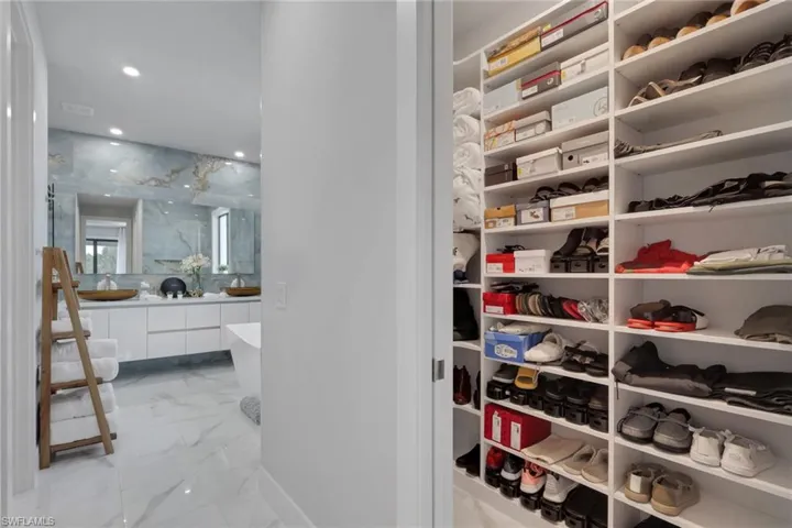 Primary suite walk in closet with custom storage