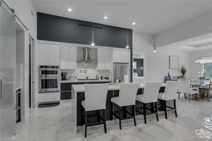 The contemporary kitchen is designed to impress with stainless steel appliances, a gas cooktop with vent hood, built-in microwave, abundant cabinetry with double drawers, generous countertop space, and a large waterfall island that's perfect for entertaining.