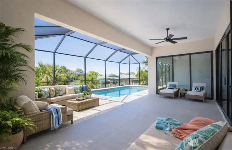 Outdoor pool featuring an outdoor hangout area, a sunroom, glass enclosure, and a patio (Rendered photo)