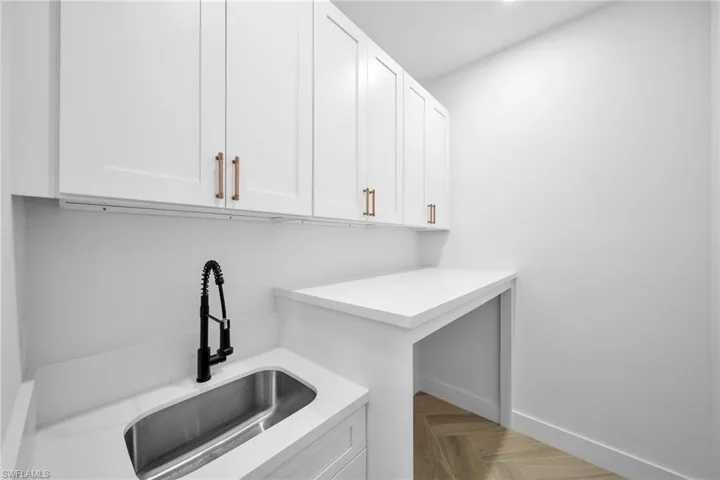 Laundry room featuring light parquet floors and sink