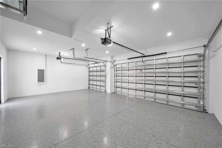 Garage featuring a garage door opener and electric panel