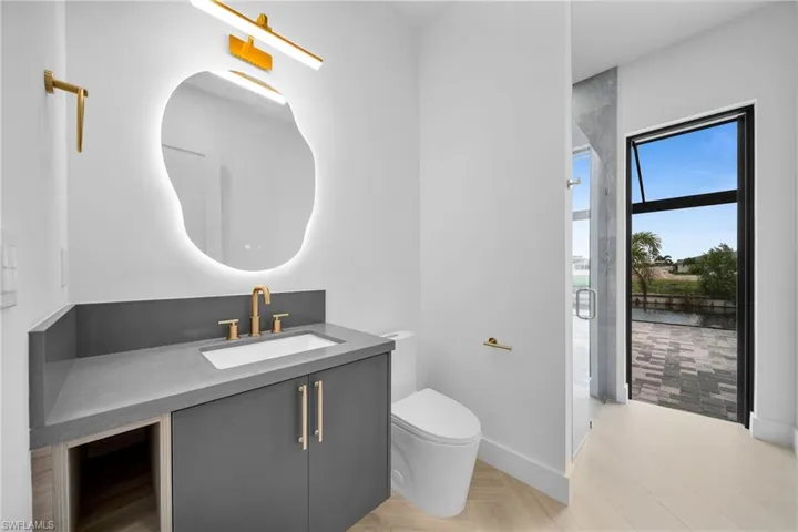 Bathroom featuring a shower with door, vanity, and toilet