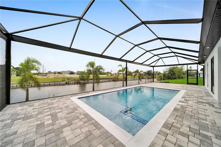 View of swimming pool featuring a lanai, a water view, and a patio area