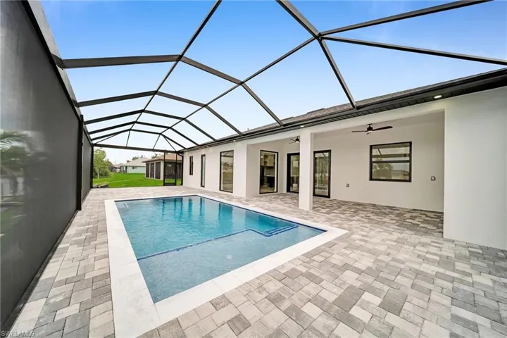 View of swimming pool featuring ceiling fan, a lanai, and a patio area