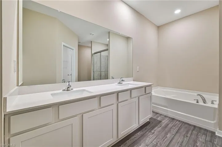 Bathroom with dual bowl vanity, separate shower and tub, and hardwood / wood-style flooring