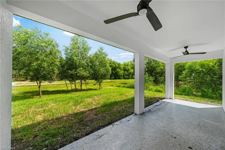 View of patio featuring ceiling fan and view of wooded area