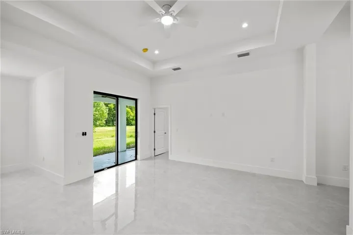 Great room with ceiling fan and tray ceiling