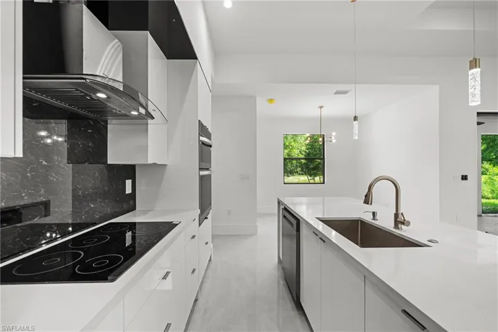 Kitchen with modern cabinets, pendant lighting, white cabinets, and black electric cooktop
