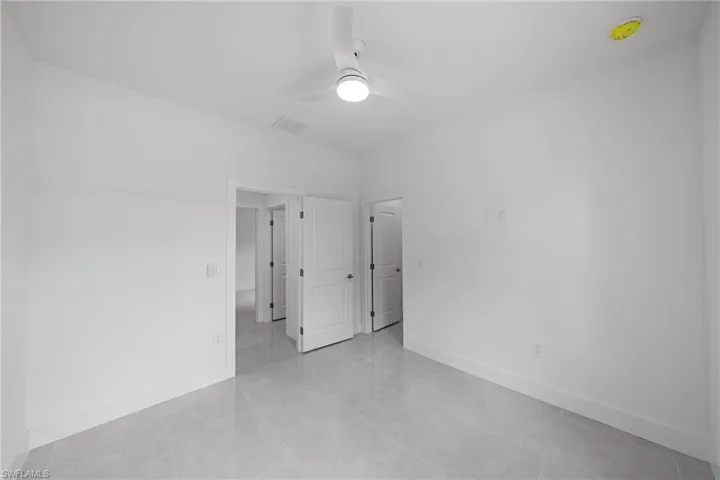 Unfurnished bedroom with a ceiling fan and baseboards