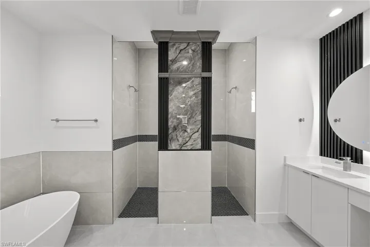 Full bath featuring a soaking tub, a walk in shower, vanity, light tile patterned flooring, and recessed lighting