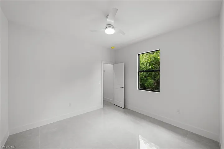 Empty room with baseboards and a ceiling fan