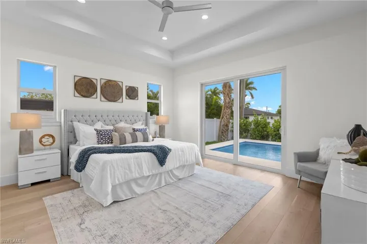 Bedroom featuring access to outside, ceiling fan, multiple windows, and light hardwood / wood-style flooring