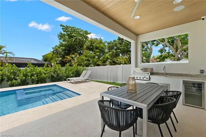View of swimming pool featuring ceiling fan, sink, a patio area, and area for grilling