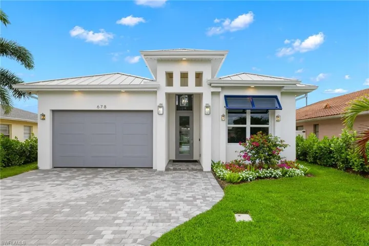 View of front of house with a garage and a front yard