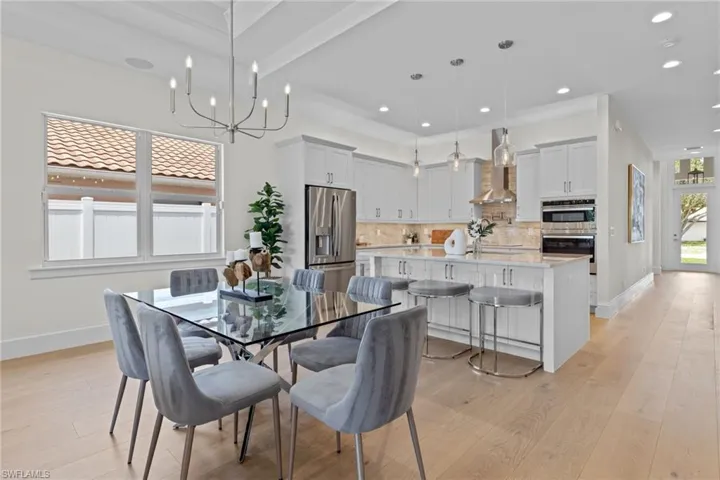 Dining room featuring an inviting chandelier, beamed ceiling, and light hardwood / wood-style flooring