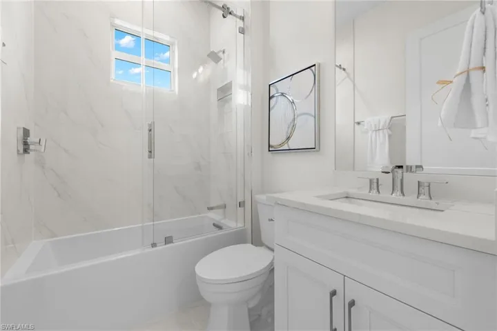 Full bathroom featuring tile flooring, oversized vanity, toilet, and tiled shower / bath combo