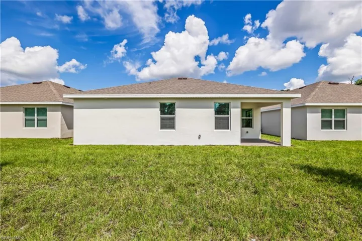 Back of property with a yard and a patio