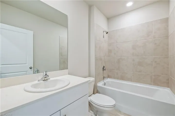 Full bathroom with vanity, toilet, and tiled shower / bath
