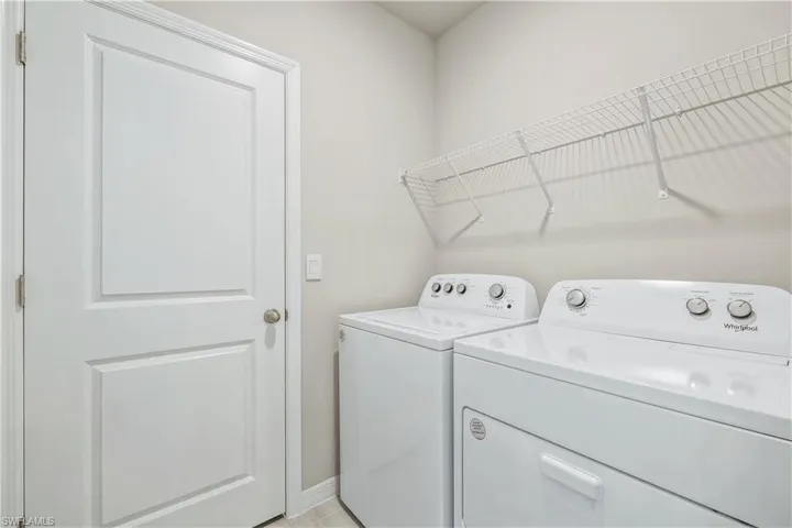 Laundry room featuring washer and dryer and light tile patterned floors