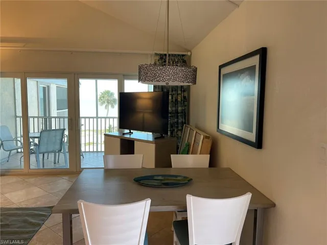 Dining room with lofted ceiling and tile patterned floors