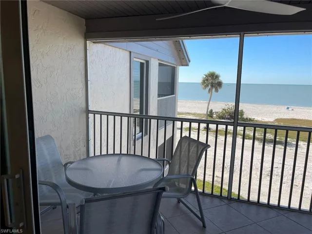 Balcony with a beach view, outdoor dining space, and a water view