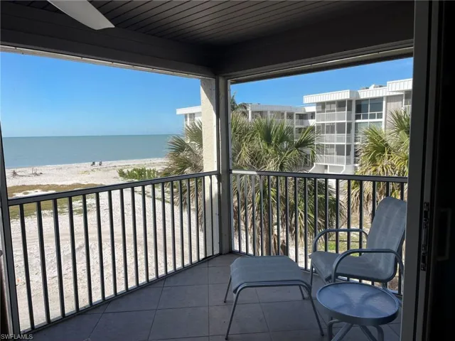 Balcony featuring a water view and a view of the beach