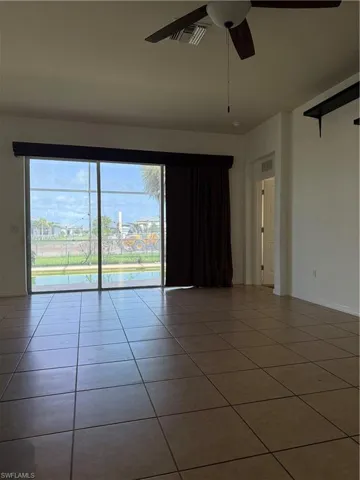 Spacious interior with large format tile flooring and a ceiling fan