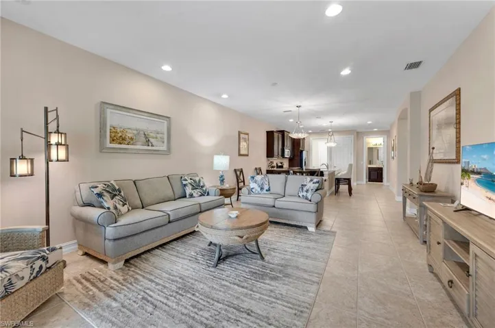 Living room featuring light tile patterned floors and a chandelier